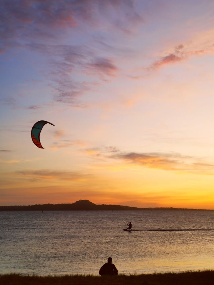 A breathtaking scene of kitesurfing at sunset on a serene sea in Cuyo, Philippines.
